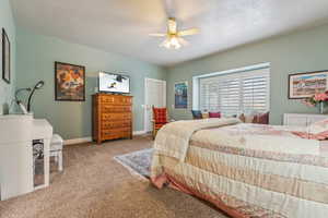 Bedroom featuring ceiling fan and carpet