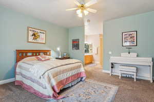 Bedroom with carpet flooring, ceiling fan, and connected bathroom