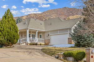 View of front of home featuring a mountain view, covered porch, and a garage