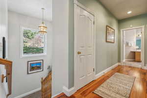 Corridor featuring hardwood / wood-style flooring and a notable chandelier