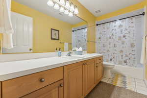 Full bathroom featuring tile patterned flooring, vanity, toilet, and shower / tub combo with curtain