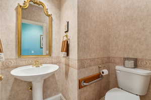 Bathroom with toilet and tile walls