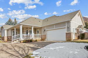 View of front facade featuring covered porch and a garage