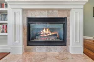 Room details featuring built in shelves, wood-type flooring, and a fireplace