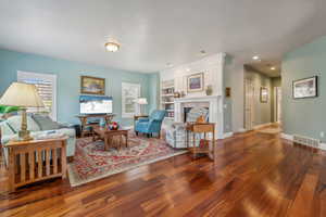 Living room featuring a fireplace and dark wood-type flooring