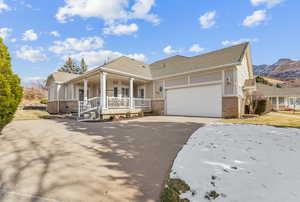 View of front of home with covered porch, a mountain view, and a garage