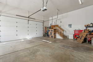 Garage featuring electric panel and a garage door opener