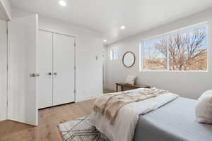 Bedroom with light hardwood / wood-style floors and a closet