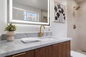 Bathroom with vanity and tiled shower