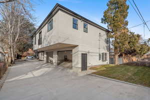 Back of house with a garage and a yard