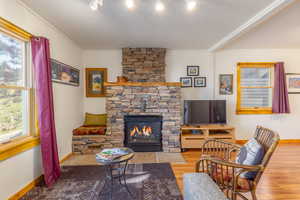 Living room featuring a fireplace, wood-type flooring, and crown molding