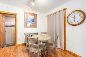 Dining space with light hardwood / wood-style floors and ornamental molding