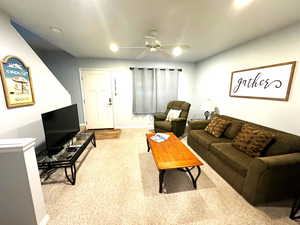 Living room featuring light carpet and ceiling fan