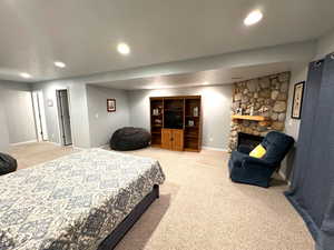 Bedroom featuring carpet flooring and a fireplace