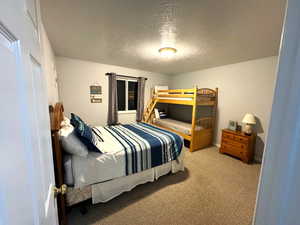 Bedroom featuring carpet floors and a textured ceiling