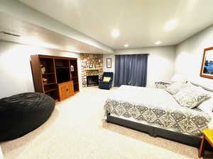 Bedroom with carpet flooring and a fireplace