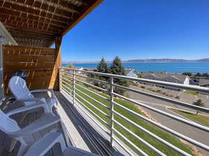 Balcony featuring a water and mountain view