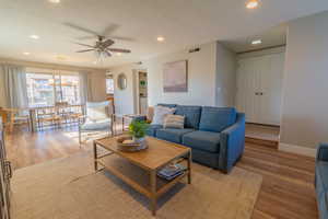 Living room featuring wood-type flooring and ceiling fan