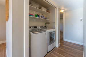 Washroom featuring hardwood / wood-style flooring and washer and dryer