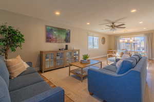 Living room featuring a wealth of natural light, ceiling fan, and light wood-type flooring