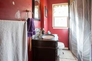 Bathroom with vanity, toilet, and a healthy amount of sunlight