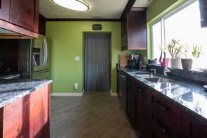 Kitchen featuring crown molding, hardwood / wood-style floors, stainless steel appliances, and sink