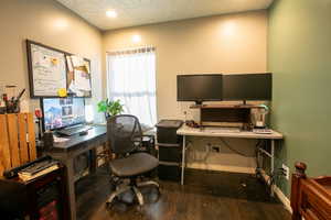 Office space with wood-type flooring and a textured ceiling