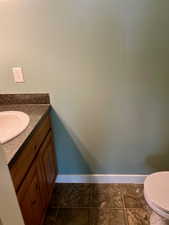 Bathroom featuring tile patterned flooring, vanity, and toilet