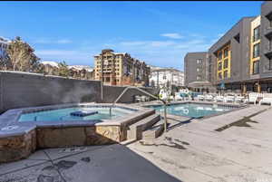 View of swimming pool with a hot tub