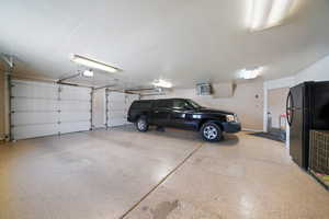 Garage featuring black fridge and a garage door opener