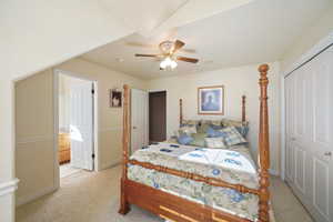 Carpeted bedroom featuring ceiling fan, a closet, and ensuite bathroom