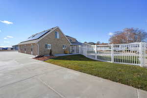 View of property exterior with a yard and solar panels