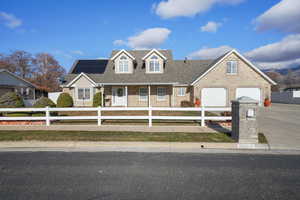 View of front facade featuring solar panels and a garage