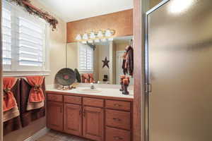 Bathroom with vanity and a shower with door