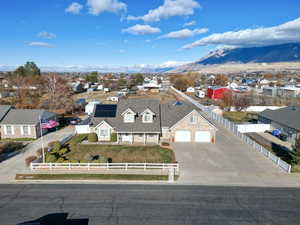 View of front of property with a mountain view, a front yard, and a garage