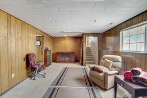 Sitting room with light colored carpet and wooden walls