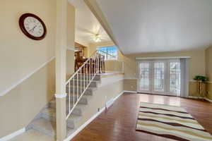 Stairway featuring hardwood / wood-style floors, french doors, and ceiling fan