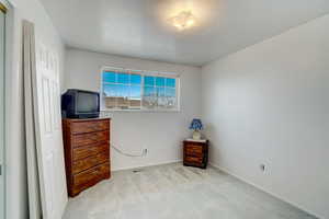 Bedroom with light carpet and a textured ceiling