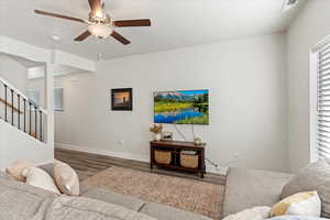 Living room with ceiling fan and wood-type flooring