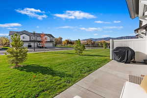 View of yard featuring a mountain view, a garage, and a patio