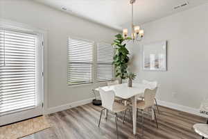 Dining room featuring an inviting chandelier and hardwood / wood-style flooring