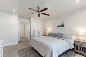 Bedroom with ceiling fan and light carpet