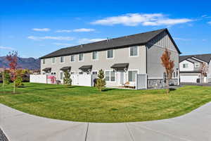 View of front facade featuring central AC unit, a mountain view, and a front lawn