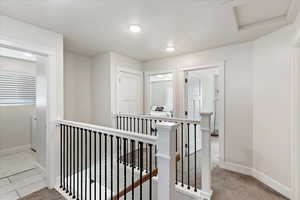 Hall with carpet flooring and a textured ceiling