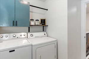 Laundry room with washing machine and clothes dryer and cabinets