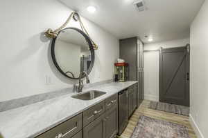 Bathroom with hardwood / wood-style floors, vanity, and a textured ceiling