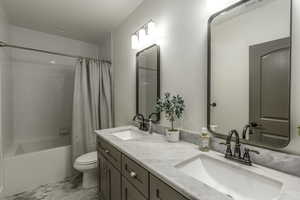 Full bathroom with vanity, toilet, and shower / bath combo with shower curtain