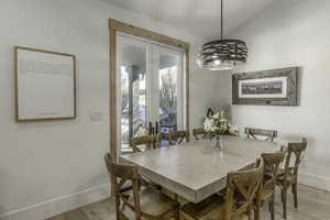 Dining space featuring light wood-type flooring, french doors, a wealth of natural light, and vaulted ceiling