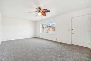 Empty room featuring carpet flooring and ceiling fan