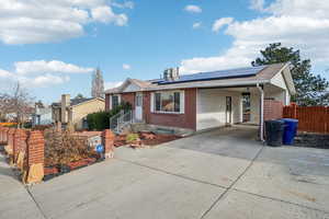 Ranch-style home with a carport and solar panels